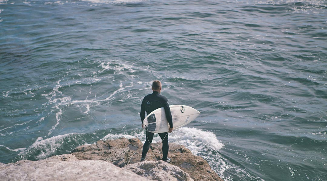 material zum surfen - surfer an klippe